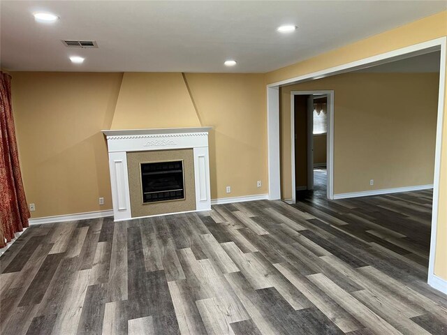 unfurnished living room featuring recessed lighting, baseboards, visible vents, and dark wood-type flooring