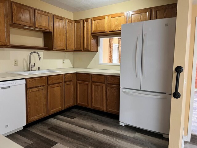 kitchen featuring a sink, white appliances, and dark wood-type flooring