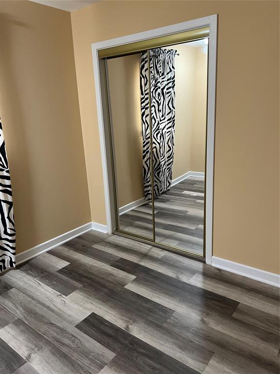 interior space with baseboards and wood finished floors
