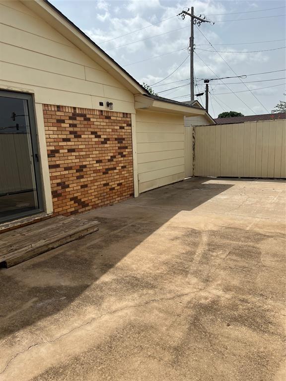 view of home's exterior featuring brick siding and fence
