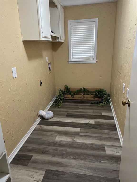 clothes washing area with hookup for an electric dryer, baseboards, wood finished floors, and hookup for a washing machine