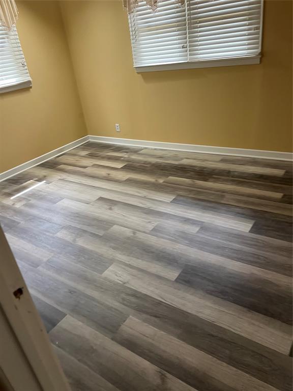 empty room with baseboards and wood finished floors