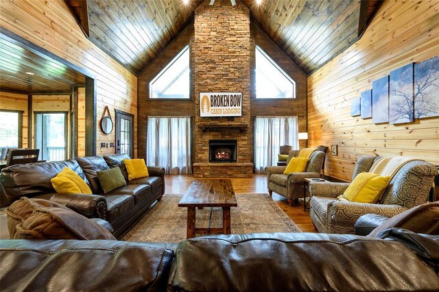 living area featuring a wealth of natural light, wooden walls, and high vaulted ceiling
