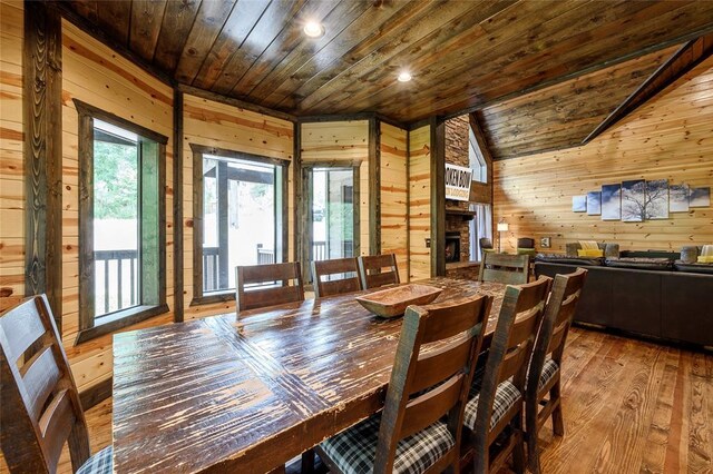 dining space featuring wood-type flooring, wood walls, and wood ceiling