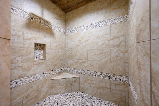 bathroom with wooden ceiling and tiled shower