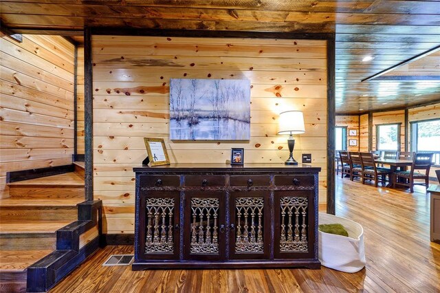 interior space with wooden walls, visible vents, wooden ceiling, and wood finished floors