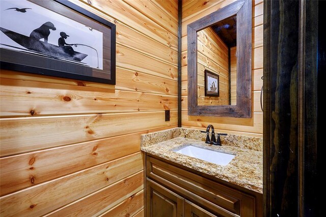 bathroom with wooden walls and vanity