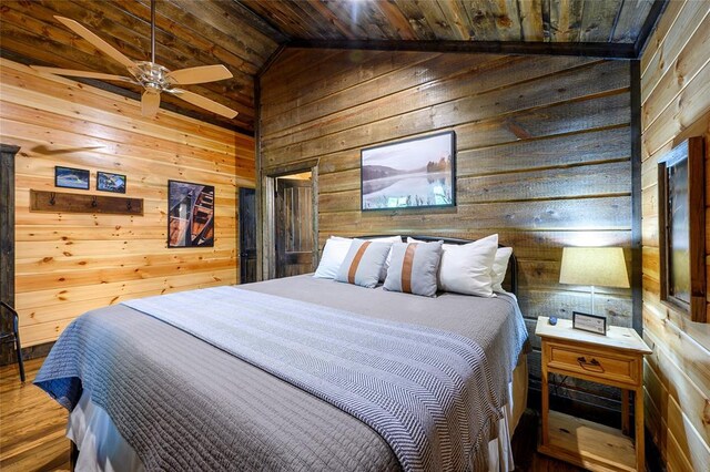 bedroom featuring wood walls, wood finished floors, vaulted ceiling, and wooden ceiling