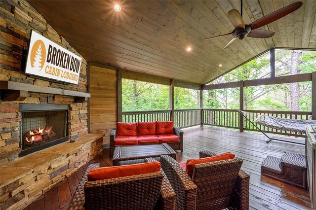sunroom / solarium with ceiling fan and an outdoor living space with a fireplace