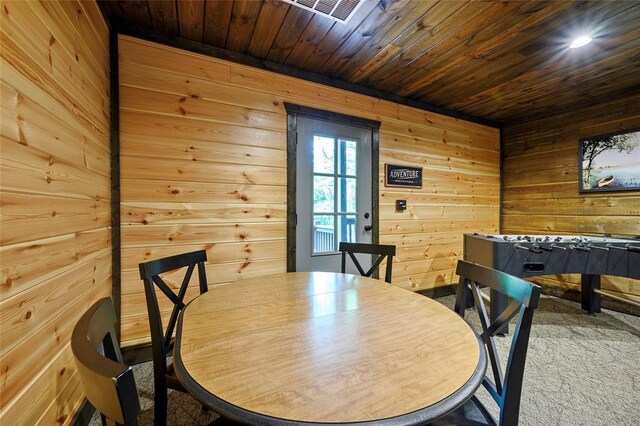 dining space with wooden ceiling, wood walls, and visible vents