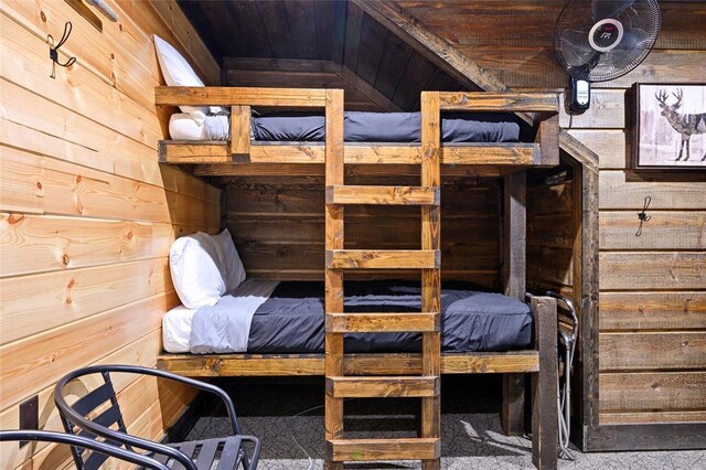 bedroom featuring lofted ceiling, wooden walls, and wooden ceiling