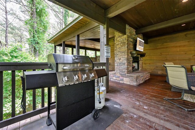wooden deck featuring an outdoor stone fireplace