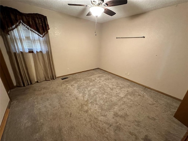 spare room featuring carpet floors, a ceiling fan, a textured ceiling, and baseboards