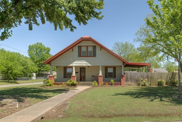 bungalow with a porch, fence, and a front yard