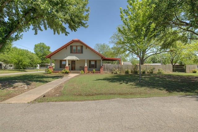 bungalow-style home with a porch, a front lawn, and fence