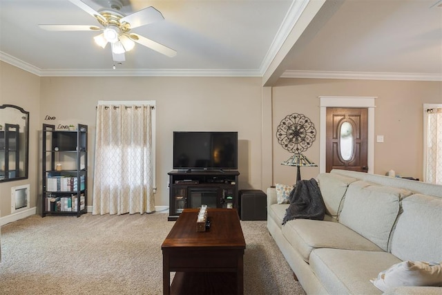carpeted living area with crown molding, ceiling fan, and baseboards
