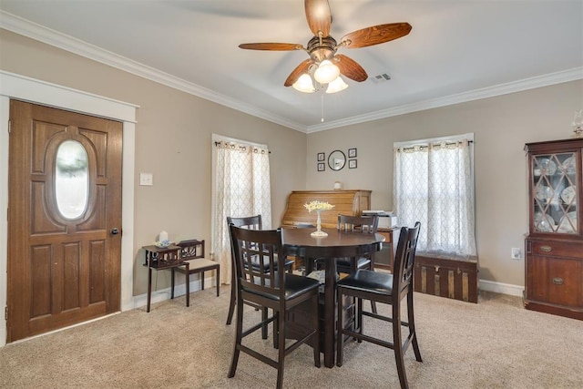 dining space with visible vents, ornamental molding, ceiling fan, and light colored carpet