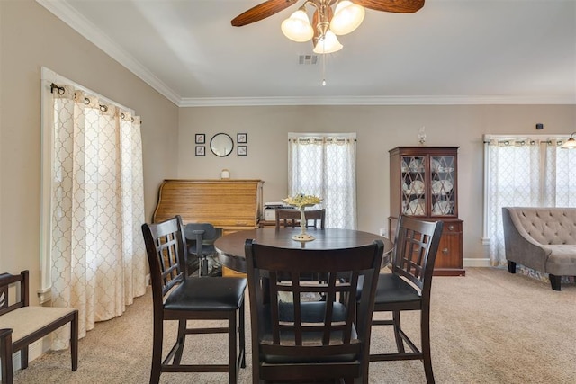 dining room featuring ornamental molding, carpet, ceiling fan, and visible vents
