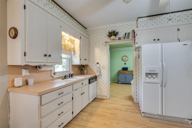 kitchen featuring light wood-style flooring, light countertops, white cabinets, wallpapered walls, and white appliances