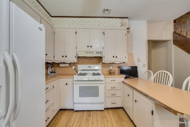 kitchen with white appliances, under cabinet range hood, visible vents, and light countertops