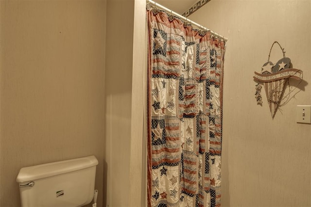 full bath with toilet and a shower with shower curtain