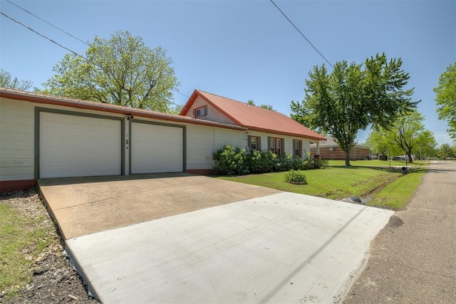 single story home with concrete driveway, an attached garage, and a front yard