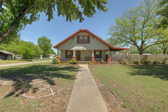 bungalow featuring fence, covered porch, and a front yard