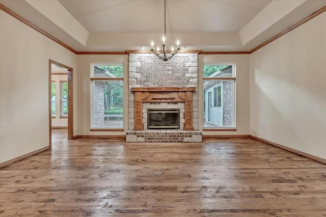 1008 Bavarian Dr, Edmond, OK 73034 - unfurnished living room featuring wood finished floors, a chandelier, a tray ceiling, and ornamental molding