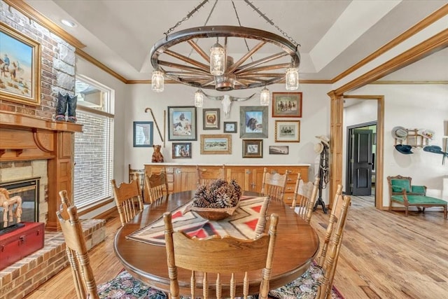 1008 Bavarian Dr, Edmond, OK 73034 - dining area featuring light wood-type flooring, ornamental molding, and a fireplace