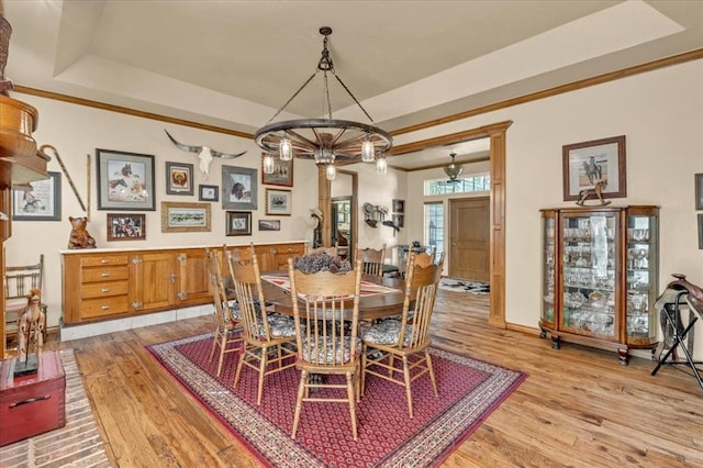 1008 Bavarian Dr, Edmond, OK 73034 - dining room with light wood-type flooring, a chandelier, a raised ceiling, and ornamental molding