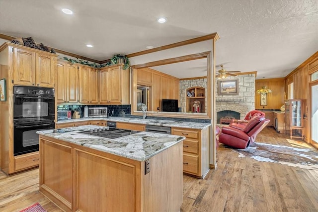 1008 Bavarian Dr, Edmond, OK 73034 - kitchen with gas stovetop, open floor plan, a center island, light wood-type flooring, and light stone counters