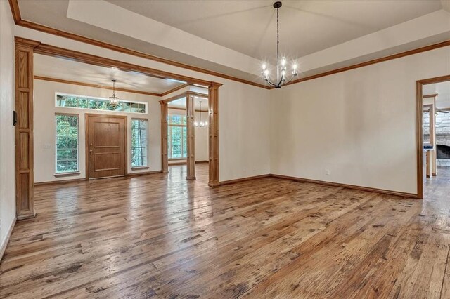 1008 Bavarian Dr, Edmond, OK 73034 - empty room featuring wood-type flooring, a tray ceiling, a chandelier, and ornamental molding