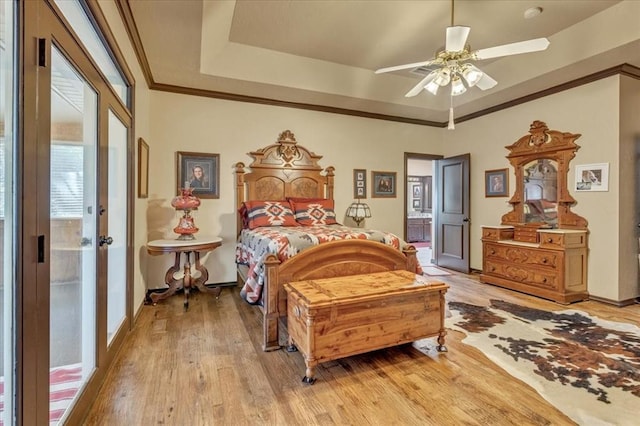 1008 Bavarian Dr, Edmond, OK 73034 - bedroom with light wood-type flooring, a tray ceiling, ceiling fan, and crown molding