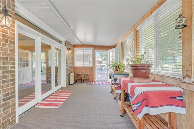 1008 Bavarian Dr, Edmond, OK 73034 - sunroom / solarium with carpet, wooden walls, lofted ceiling, and brick wall