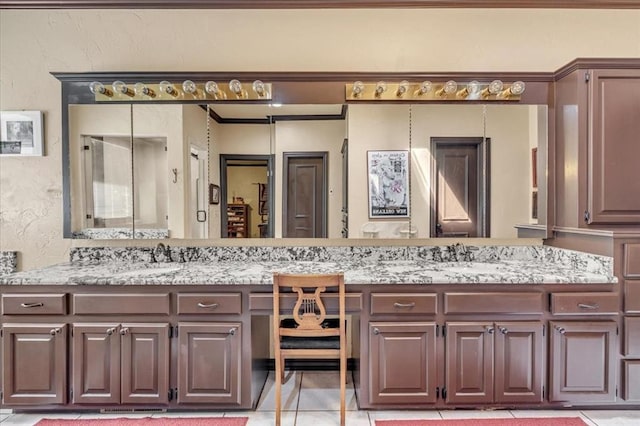 1008 Bavarian Dr, Edmond, OK 73034 - bathroom featuring double vanity, tile patterned flooring, and a textured wall