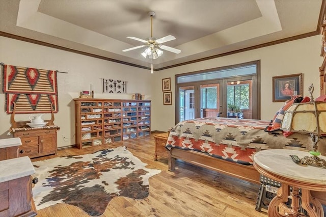 1008 Bavarian Dr, Edmond, OK 73034 - bedroom featuring a tray ceiling, access to exterior, light wood finished floors, and ornamental molding