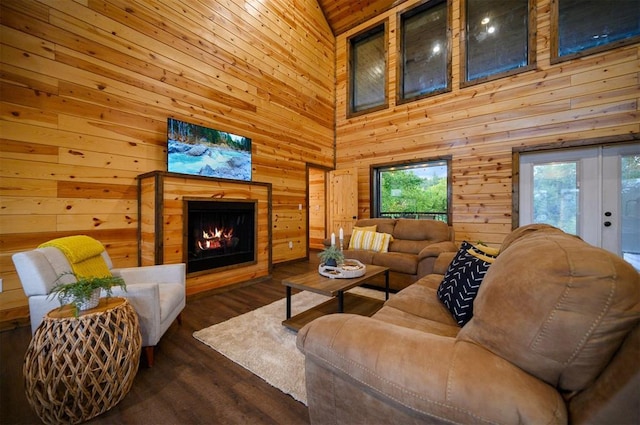 370 Stones River Ln, Broken Bow, OK 74728 - living room with wooden walls, a warm lit fireplace, a towering ceiling, and wood finished floors