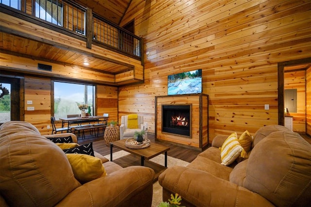 370 Stones River Ln, Broken Bow, OK 74728 - living area featuring wooden walls, wood finished floors, a lit fireplace, and a towering ceiling