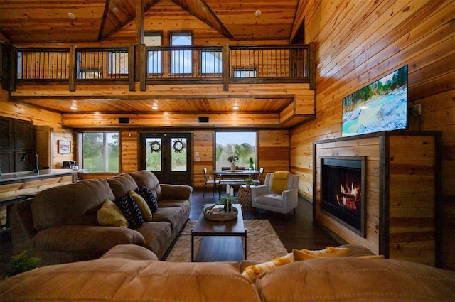 370 Stones River Ln, Broken Bow, OK 74728 - living room featuring wooden walls, wood finished floors, healthy amount of natural light, wood ceiling, and a lit fireplace