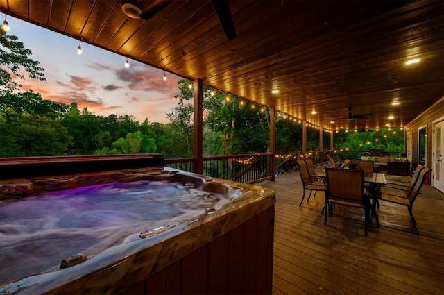 370 Stones River Ln, Broken Bow, OK 74728 - deck at dusk with a hot tub, ceiling fan, and outdoor dining space