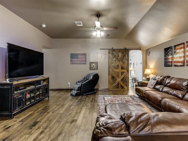 living area featuring ceiling fan, visible vents, a barn door, wood finished floors, and lofted ceiling