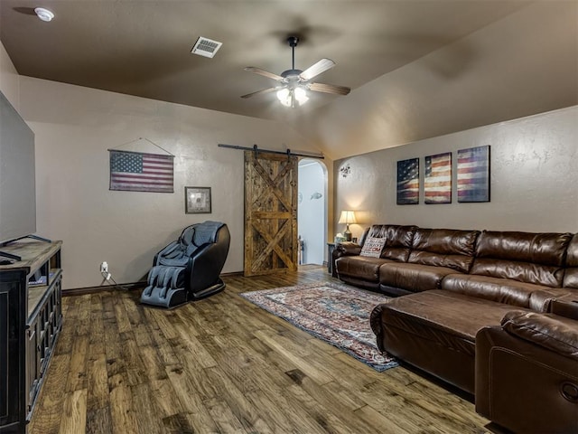 living room featuring visible vents, wood finished floors, ceiling fan, a barn door, and vaulted ceiling