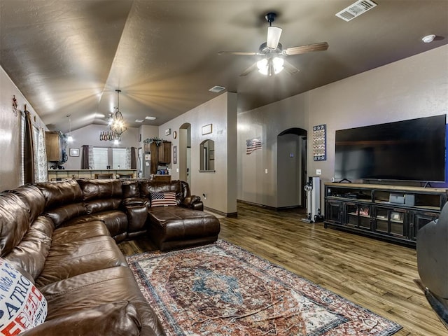 living area with arched walkways, ceiling fan, wood finished floors, and visible vents