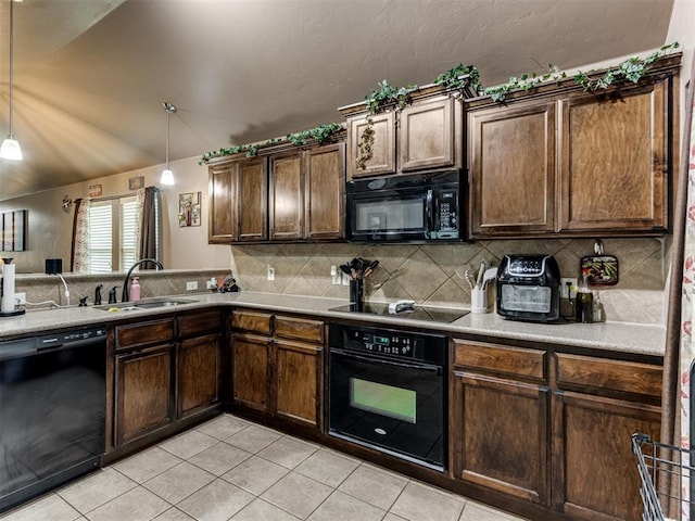 kitchen featuring a sink, light tile patterned floors, tasteful backsplash, and black appliances