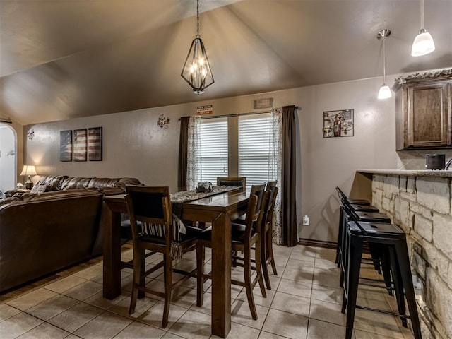 dining space with light tile patterned flooring and vaulted ceiling