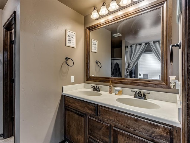 bathroom featuring a sink, double vanity, and visible vents