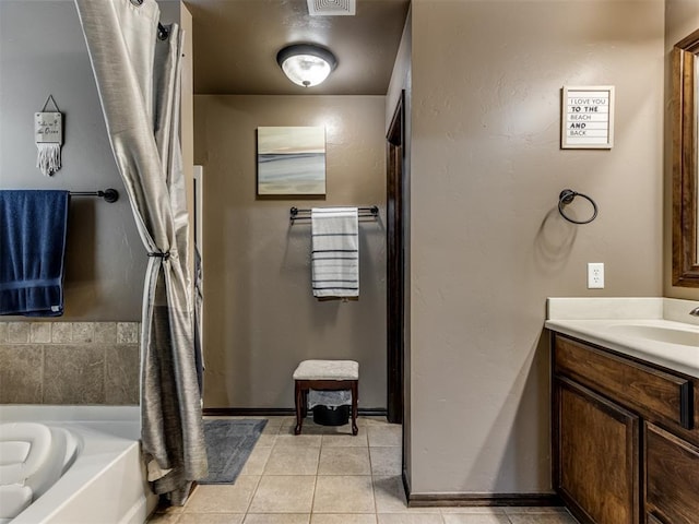 bathroom with tile patterned floors, a bathing tub, and vanity