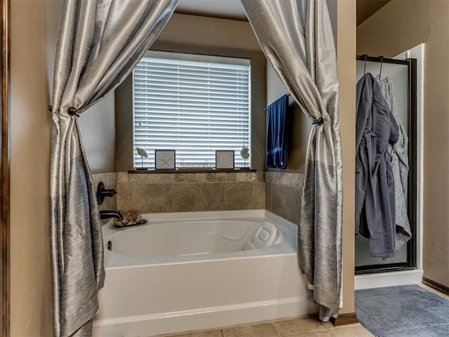 bathroom with tile patterned floors, a stall shower, and a bath