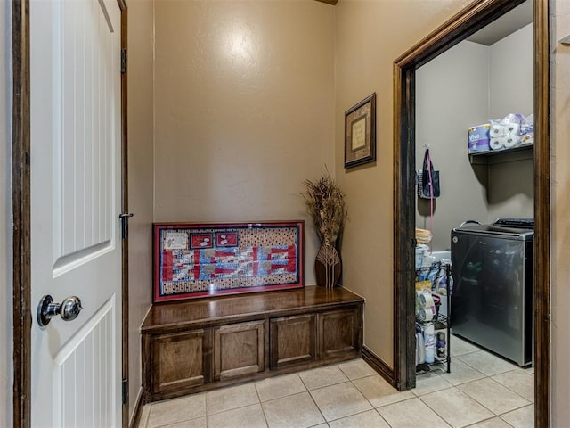 hallway featuring baseboards and light tile patterned flooring