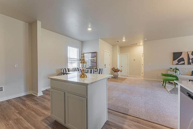 kitchen featuring baseboards, a kitchen island, light wood finished floors, and open floor plan